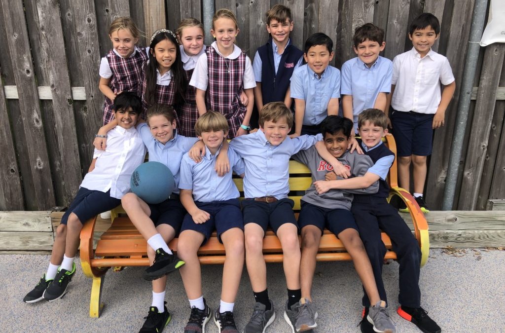 A group of students from River Oaks Baptist School sitting on a wooden bench