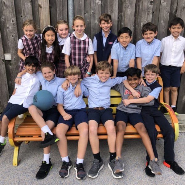 A group of students from River Oaks Baptist School sitting on a wooden bench