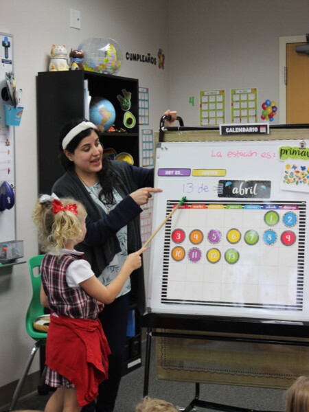 A woman teaching children how to use a whiteboard at River Oaks Baptist School