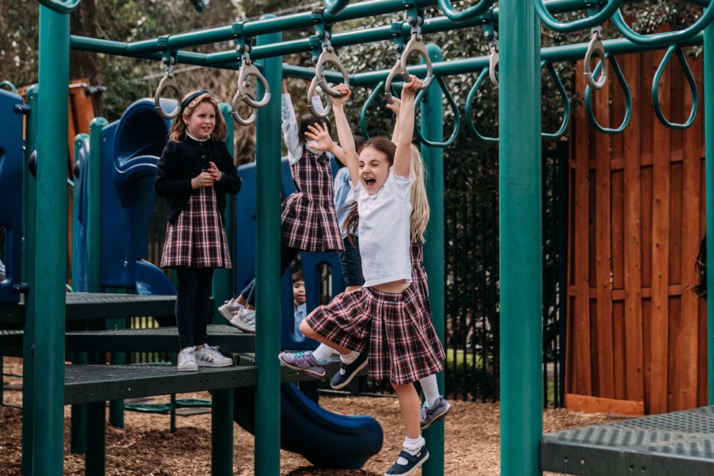 A group of children playing on a playground at River Oaks Baptist School
