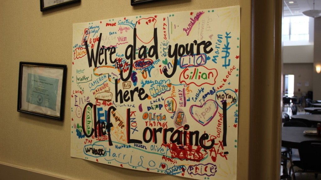 A sign on a wall that says "We're glad you're here"