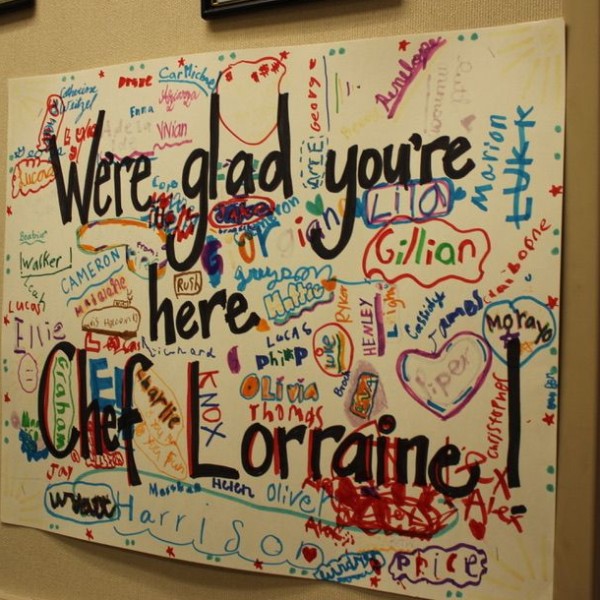 A sign on a wall that says "We're glad you're here"