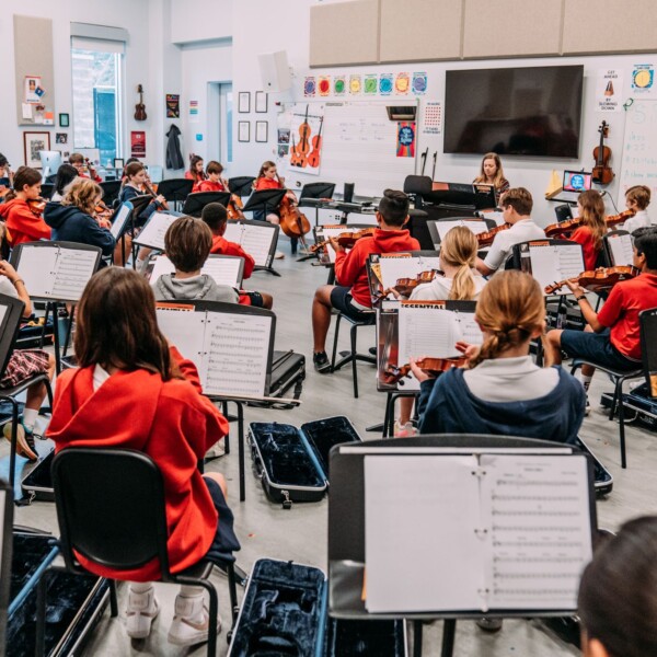 A group of students sitting in a room with musical instruments at River Oaks Baptist School