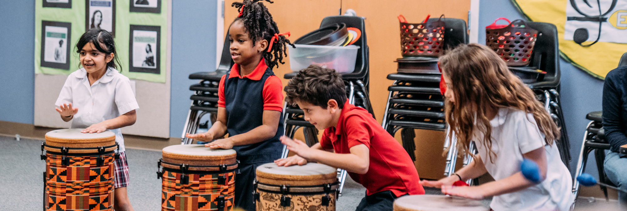 A group of children playing drums in a room at River Oaks Baptist School